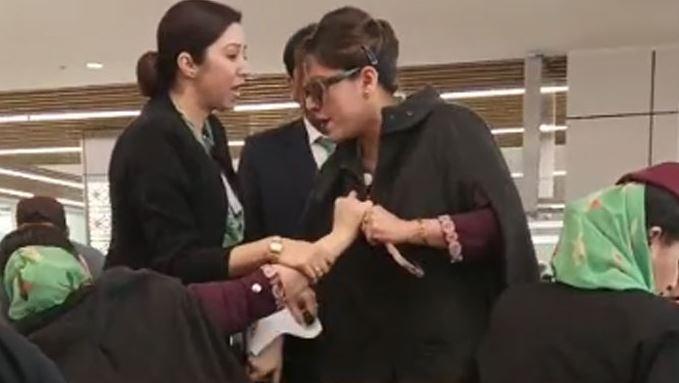 Two PIA flight attendants exchange words at Jeddah Airport's departure lounge