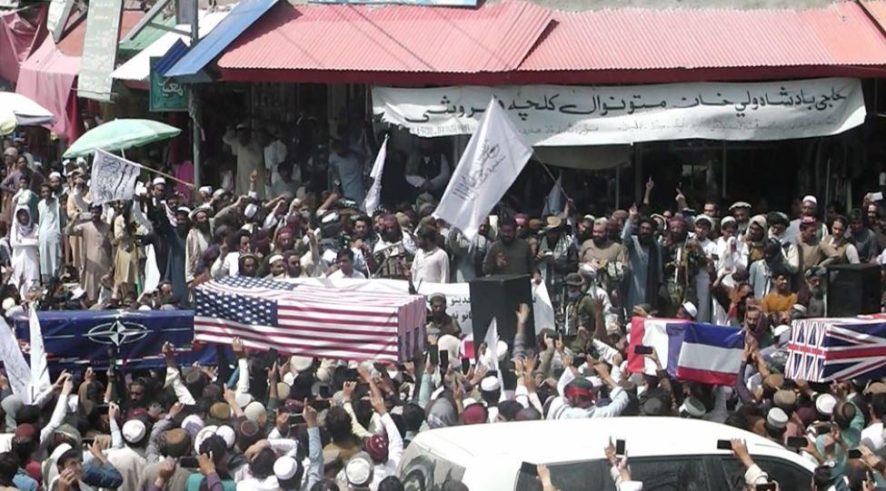 Carrying coffins draped with American and NATO flags Taliban supporters hold mock funerals