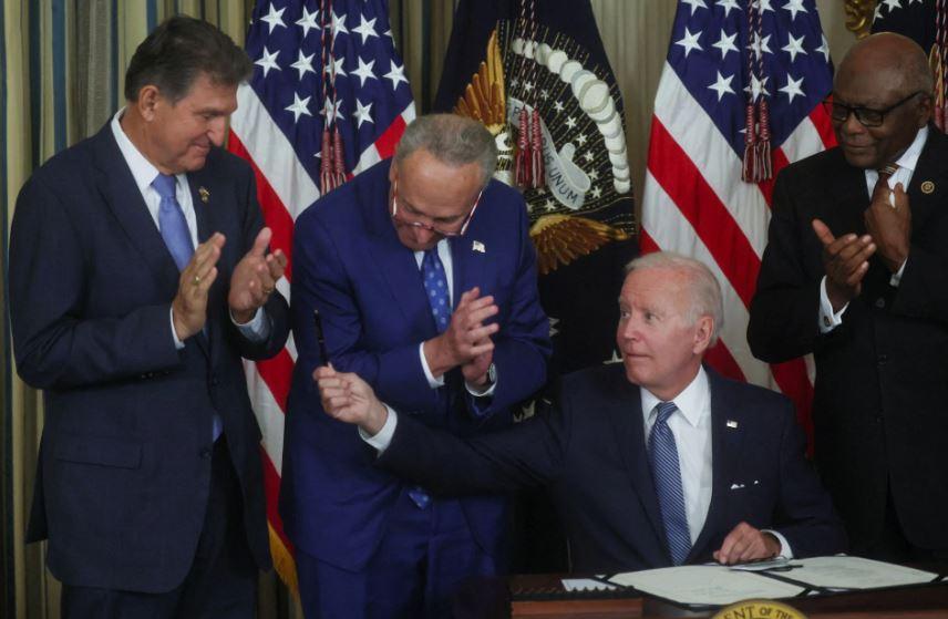 President Biden inks inflation act, hands pen to Manchin