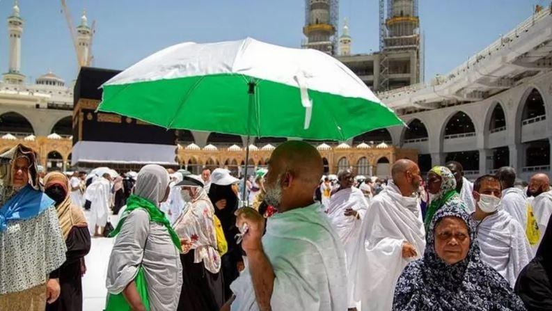 حرم میں عازمین حج میں چھتریاں تقسیم