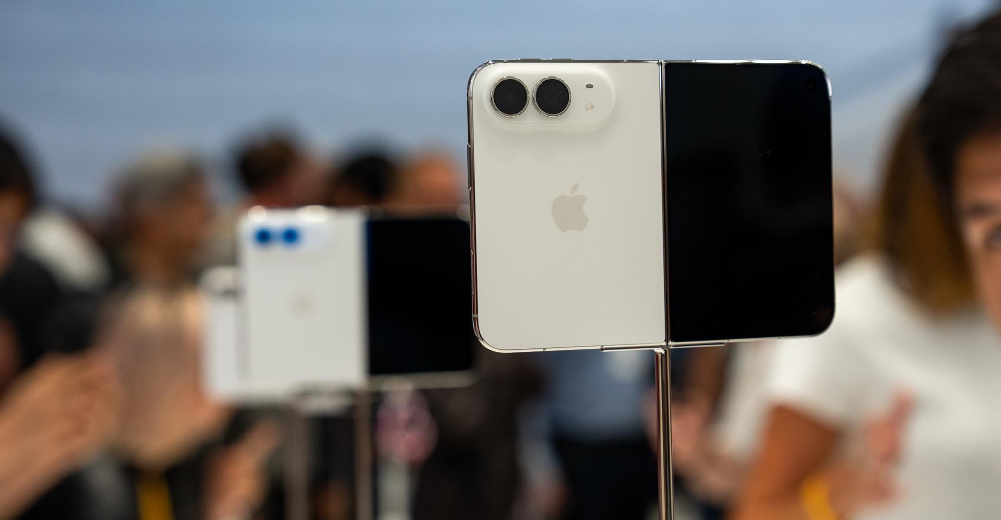 iPhone Duo in Star White partially folded showing dual 48MP rear cameras and titanium frame