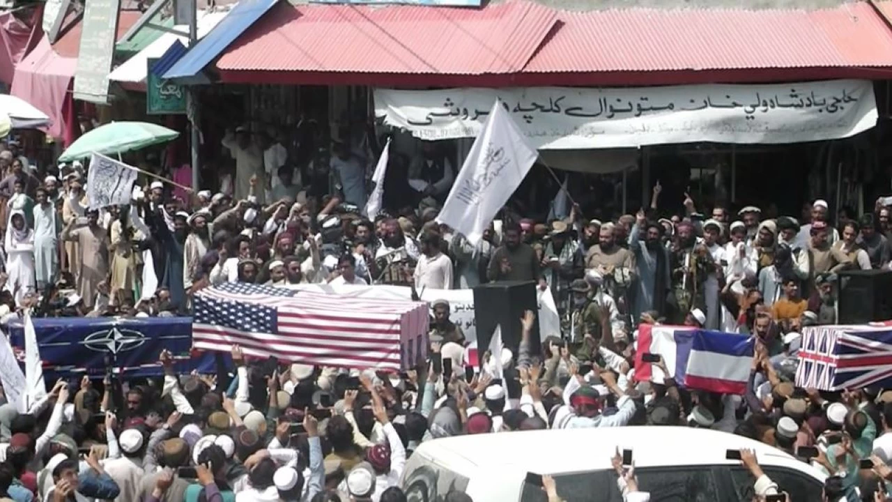 Carrying coffins draped with American and NATO flags Taliban supporters hold mock funerals