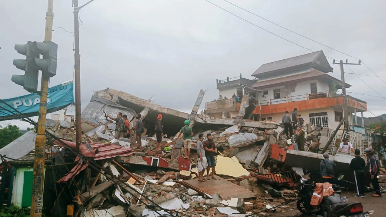 Residents inspecting earthquake-damaged buildings in Mamuju, West Sulawesi, Indonesia, on January 15, 2021 (AP)